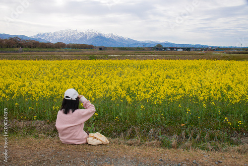 Girl in Yellow Flower Field with Mountains
