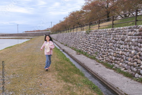 Girl Running by Stone Wall and Canal
