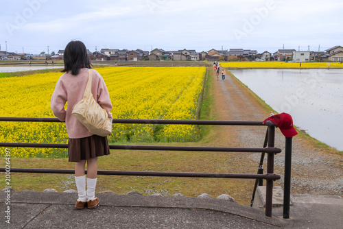 Girl in Pink Sweater by Yellow Flower Field