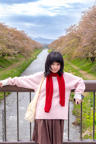 Woman Admiring Cherry Blossoms by River