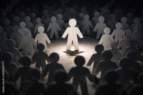 Front perspective on a single raised paper figure encircled by many others against a shadowy background symbolizing exclusion