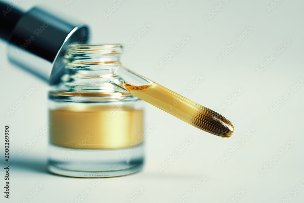 Naklejka premium Close up of transparent dropper bottle with liquid and brush for application