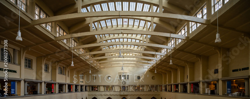 Iconic interior architecture of Stuttgarter Markthalle, featuring its distinctive vaulted ceiling with numerous skylights and exposed wooden beams, creating a bright, spacious atmosphere. Vintage pend