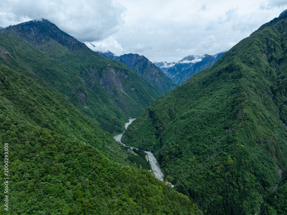 Fototapeta premium Aerial view of beautiful high altitude snow capped mountain and forest landscape