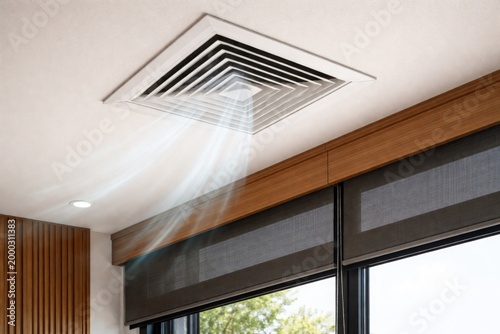 Ceiling air vent fixture made of white metal positioned near window with tinted shades and wooden treatments