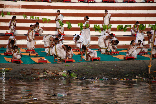 Young boys in dhoti training as Hindu monks performing ritual on Ganga ghats in Varanasi
