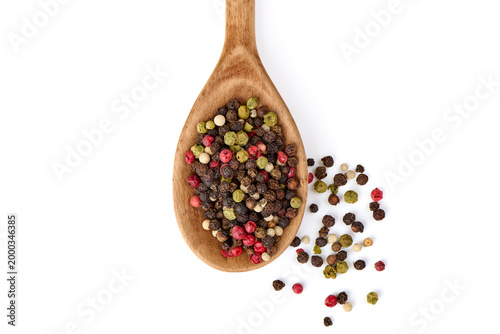 Four color peppercorns in wooden spoon, isolated on white background