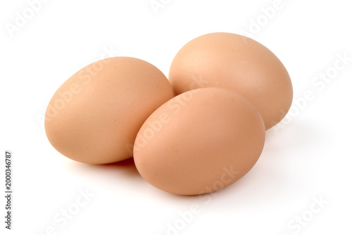 Three raw brown chicken eggs, isolated on white background