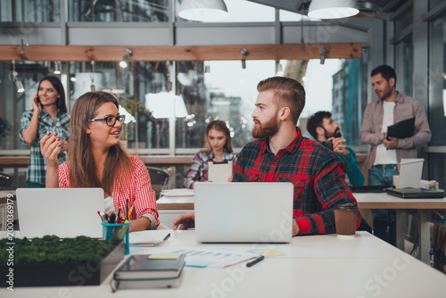 Foto Young coworkers collaborating in a modern open office workspace, casual team mee