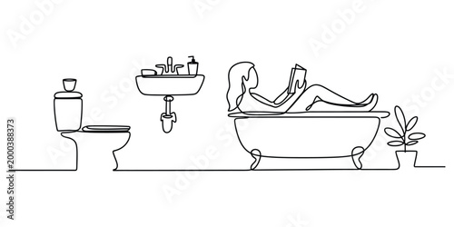 Woman reading a book while relaxing in a bathtub