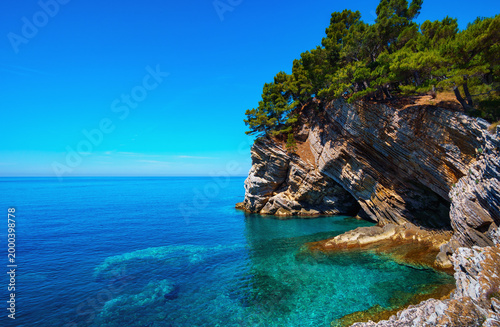 Beautiful hidden cove with crystal clear turquoise water and rocky cliffs in Petrovac Montenegro adriatic sea.