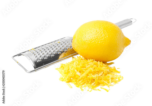 Foto Fresh lemon with stainless steel zester and lemon zest pile, citrus zesting isol