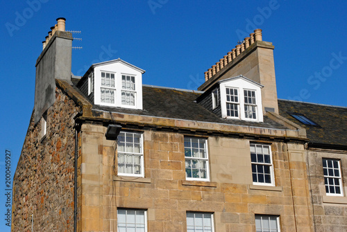 Cuadro en lienzo Facade and Dormer Windows on Old Stone Building seen from Below against Blue Sky