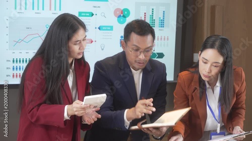 Business team meeting reviewing analytics dashboard on screen, professionals discussing data on tablet in modern office, collaboration and strategy concept.