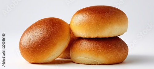 Three golden brown brioche buns stacked and arranged on a white background.