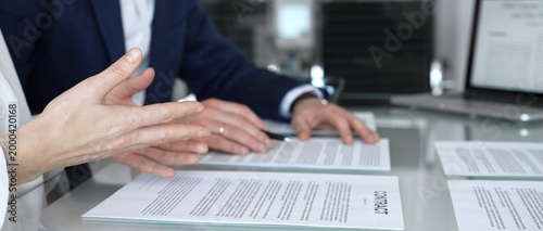 Cuadro en lienzo Business people are discussing a contract, reviewing documents and pointing with