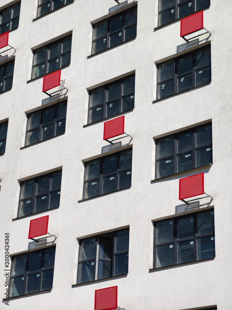 Fototapeta premium White high-rise apartment building with red air conditioner mounts