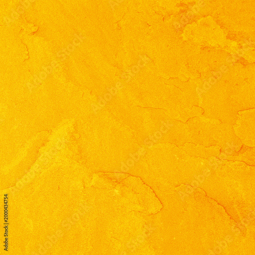A vibrant texture of orange and yellow fabric displays a natural wooden grain pattern on a light oak timber surface with a macro textured design