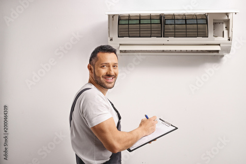 Φωτογραφία Worker inspecting an indoor air conditioning unit