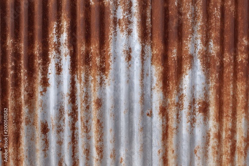 Rusted galvanized steel roof corrugated texture with oxidation patterns.