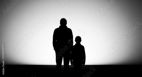 Father and Son Silhouette Standing Together Against Bright Light.