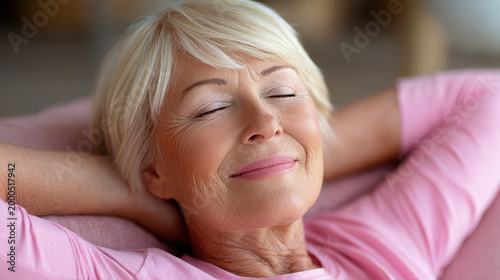 Elderly woman relaxing with eyes closed and smiling indoors  