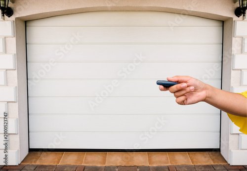 Garage door PVC. Hand use remote controller for closing and opening garage door
