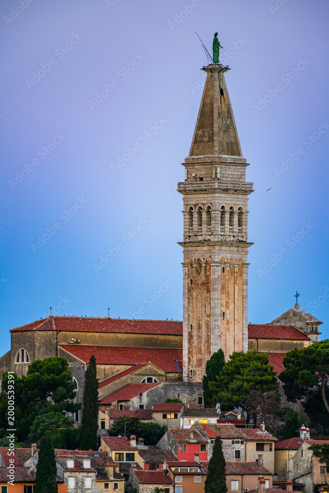 Obraz premium Coastline of Adriatic sea and The bell tower of Church of St. Euphemia and the old city of Rovinj, Istria, Croatia in a blue hour twilight dawn.