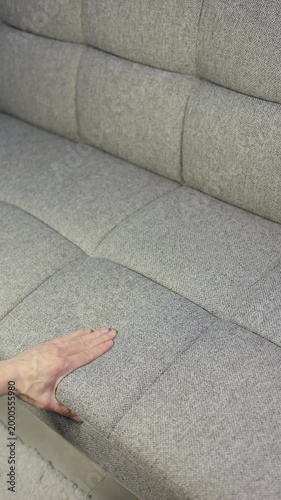Vertical video of choosing soft sofa in furniture store. Close, up. Slow motion footage.