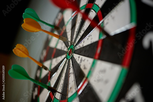 Close up of darts hitting bullseye on dartboard, showing accuracy, goal achievement, winning strategy, performance metrics. Ideal for business targets, success planning, KPI concepts
