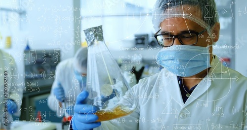 Tech in PPE, blue nitrile gloves inspecting conical flask with yellow liquid in lab, math overlays