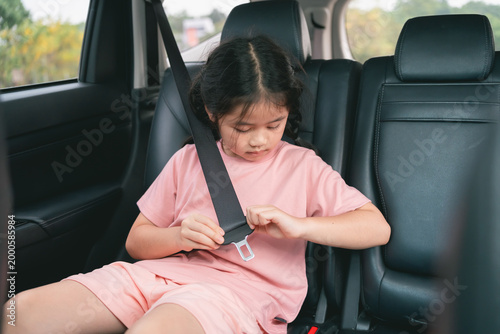 Young Girl Fastening Seat Belt Inside Car, Safety First Concept, Child Transportation, Vehicle Interior, Family Road Trip, Child in Auto, Travel Safety