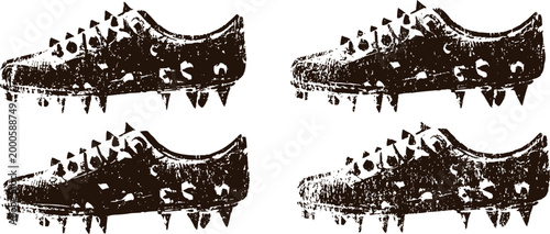 four grunge black football cleats with spikes in rough textured isolated on white