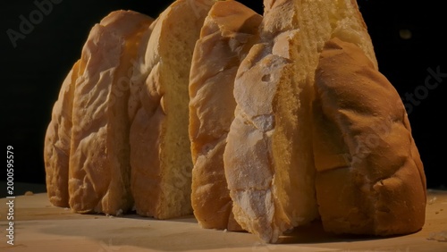 Close up of freshly sliced bread lined up on a wooden surface. Concept of homemade food, bakery products, content for bakeries and bread factories, store, supermarket, gastronomy and culinary art