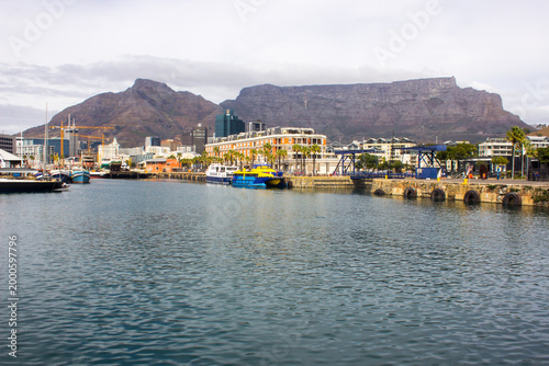 View at the V&A waterfront at the old port of Cape Town with Table mountain in the background on an overcast day.