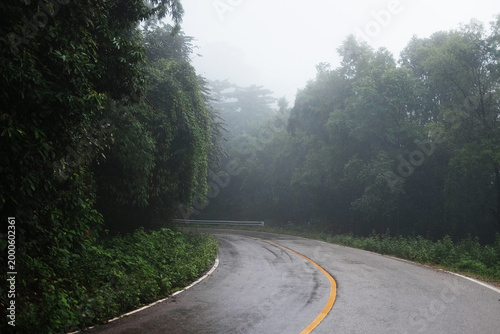 Widding road in rainy foggy and mist after rain and tropical forest in Thailand