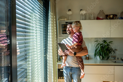 Foto Father showing smart home control to toddler while managing exterior shading system