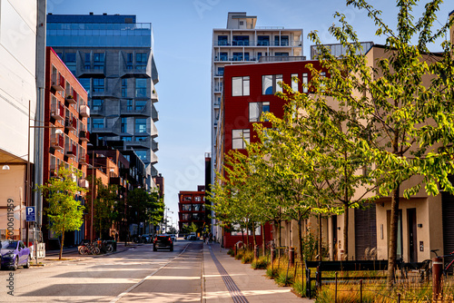 The modern green district of Nordhavn in Copenhagen with people running, cars, life on streets Denmark.