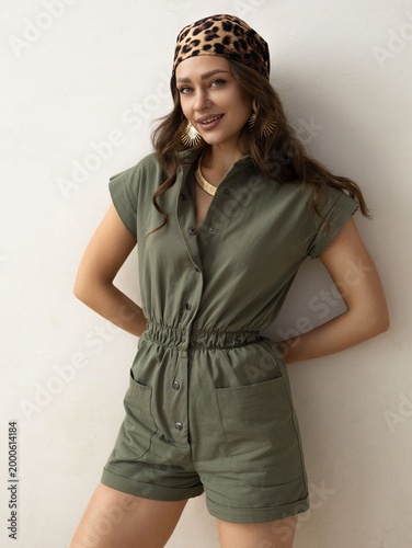 Canvastavla Stylish Young Woman in Casual Olive Green Outfit with Accessories Posing Confide