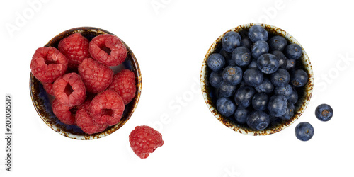 two bowls of fresh raspberries and blueberries ioslated on white or transparent png