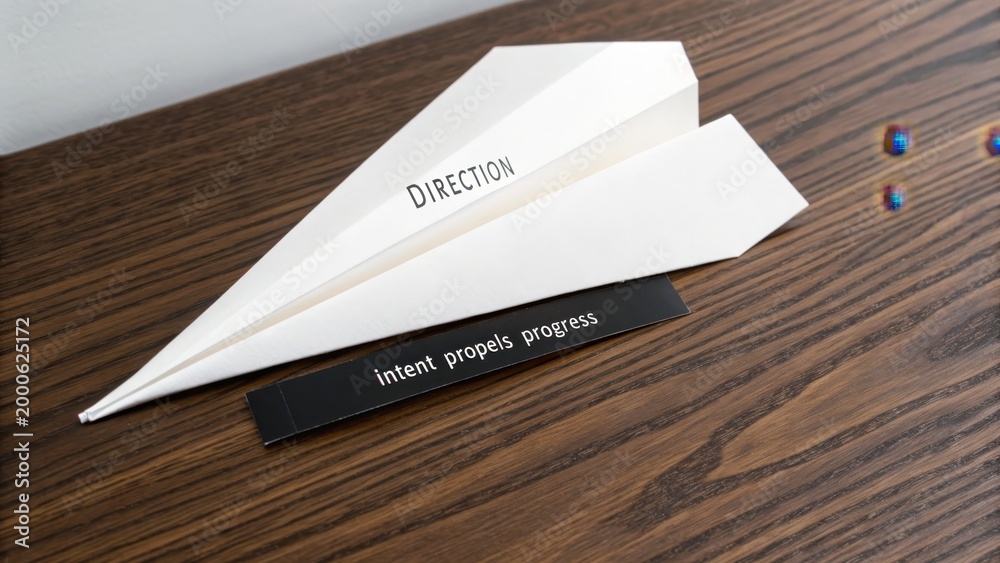 Naklejka premium White paper airplane with inspirational quotes on wood