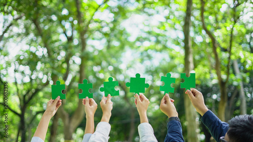 Teamwork Coworker's hand holding jigsaw puzzle With the cooperation of business people join together to campaign Environment concept, Copy space for your text.