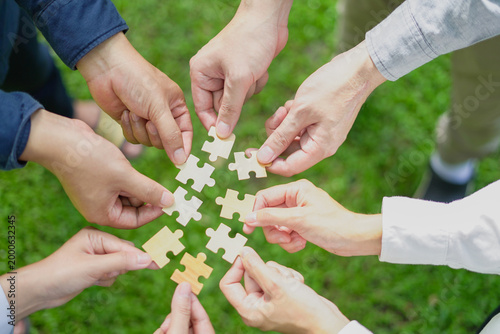Teamwork Coworker's hand holding jigsaw puzzle With the cooperation of business people join together to campaign Environment concept, Copy space for your text.