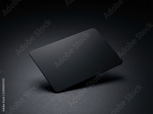 Matte black blank card floating on a dark textured surface for minimalist background and product presentation banner design and studio mockup
