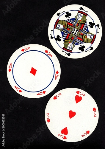 A hand of three vintage round playing cards isolated on a black background.