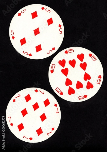 A hand of three vintage round playing cards isolated on a black background.