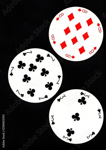 A hand of three vintage round playing cards isolated on a black background.