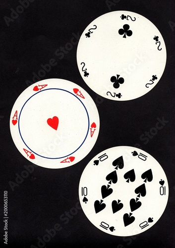 A hand of three vintage round playing cards isolated on a black background.