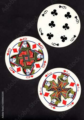 A hand of three vintage round playing cards isolated on a black background.