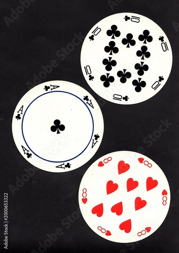 A hand of three vintage round playing cards isolated on a black background.
